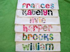 four pieces of white fabric with colorful letters and numbers on them, all in different colors