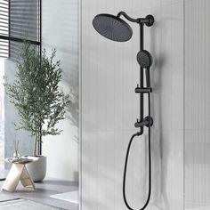 an open shower head and hand shower in a white bathroom with black accents on the walls