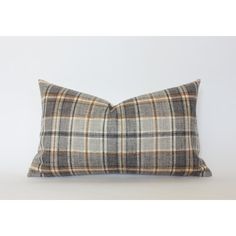 a plaid pillow sitting on top of a white wall