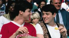 two young men sitting next to each other in front of a crowd