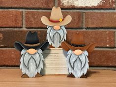 three gnome figurines sitting on top of a wooden table