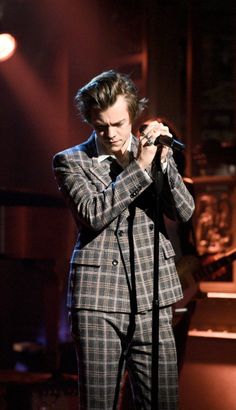 a man in plaid suit singing into a microphone