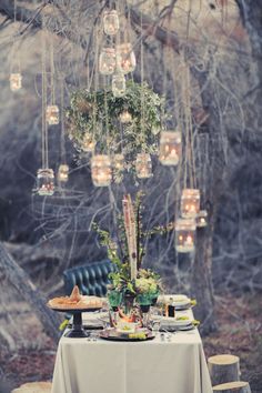 there are many lights hanging from the branches in the tree and on the table is a vase filled with flowers