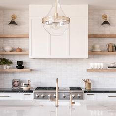 a modern kitchen with white cabinets and gold accents