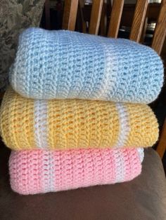 three knitted blankets stacked on top of each other