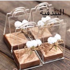 four pieces of chocolate with white flowers tied in twine on wooden table next to each other