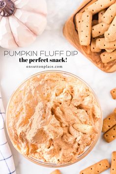 pumpkin fluff dip in a glass bowl next to crackers on a white surface