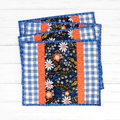 two blue and orange place mats with flowers on them