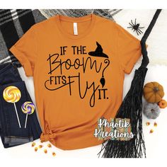 an orange shirt with the words if the broom fits fit it on it next to some candy