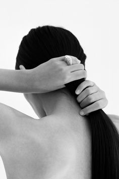 a woman with her hair in a ponytail is touching the back of another woman's head