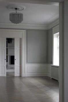 an empty room with white walls and wood flooring is seen from the doorway to the living room