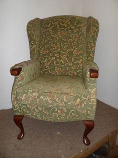 a green chair sitting on top of a carpeted floor next to a white wall