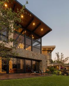 a modern house with large windows and lights on the roof