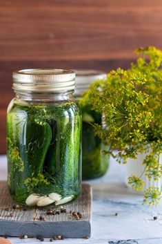 pickles and herbs in jars on a table