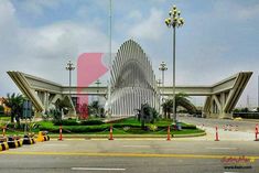 a large building sitting on the side of a road next to palm trees and traffic cones