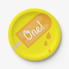 a yellow paper plate with an orange popsicle on it and the word one written in white