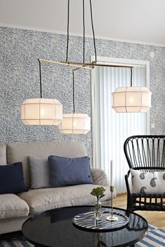 a living room with blue and white wallpaper on the walls, two chairs and a coffee table