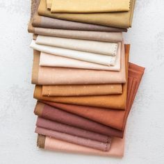 a stack of different colored fabrics on top of each other in various sizes and colors