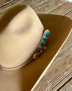 Put a unique rustic twist on your look with this one-of-a-kind Turquoise Chunks Leather Hat Pick by McIntire Saddlery. This hand tooled and hand painted hat pick features a gorgeous turquoise chunks design that is sure to make you stand out from the crowd. So, grab this pick and show off your style! Features: Hand tooled leather Turquoise Stone Chunk design Hand Painted Measures: Handmade Southwestern Turquoise Hat Bands, Southwestern Turquoise Hat For Ranch, Southwestern Style Turquoise Hat For Ranch, Hand Painted Western Hat Bands For Rodeo, Southwestern Turquoise Hat Band For Ranch, Southwestern Turquoise Hat With Curved Brim, Turquoise Southwestern Hat With Curved Brim, Western Style Hand Painted Hat Bands For Country Events, Artisan Hand Painted Adjustable Hat Bands