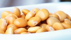 a white bowl filled with yellow beans on top of a table