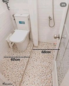 a bathroom with a toilet, shower and measurements for the size of the floor tiles