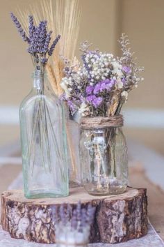 two vases filled with flowers sitting on top of a wooden table next to each other