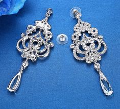 A beautiful pair of bridal earrings that is sure to make a bold statement on your Wedding Day! Adorned with glowing rhinestone crystals that capture the light from every angle with a perfectly translucent appeal, the earrings are silver plated for a bright finish which enhances the intricate detailing and conveys a modern take on old elegance. Overall length of the earring is 3.75" (approx. 9.5cm). Width: 1.25" (approx. 3.2cm). Weight: 23g. This exquisite design will add a touch of sophisticatio Rhinestone Wedding, Rhinestone Bridal, Rhinestone Jewelry, Wedding Earrings, On Your Wedding Day, Bridal Earrings, Exquisite Design, Crystal Rhinestone, Belly Button Rings