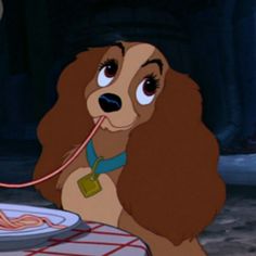 lady and the tramp is sitting at a table with food in front of her