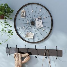 there is a bike wheel hanging on the wall next to a coat rack and purse