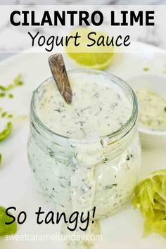 cilantro lime yogurt sauce in a glass jar on a white plate