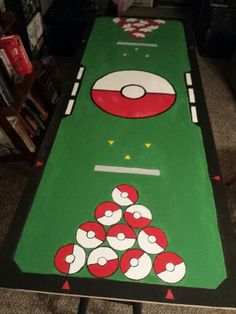 a green table with red and white balls on it in front of a bookshelf