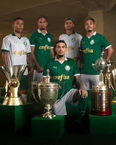 the soccer team is posing with their trophies and trophy cups in front of each other