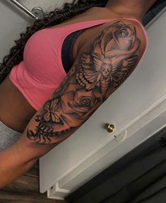 a woman with a rose and butterfly tattoo on her arm