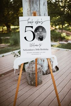 a sign that is on top of a wooden easel in front of a tree