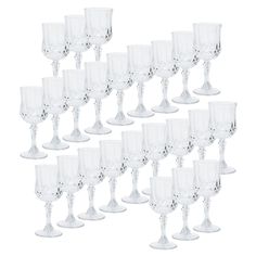 a bunch of wine glasses sitting next to each other on a white surface with no one in it