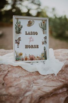 a sign that says lasso the horse with cactus and cacti on it