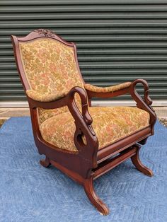 an old fashioned chair sitting on top of a blue rug