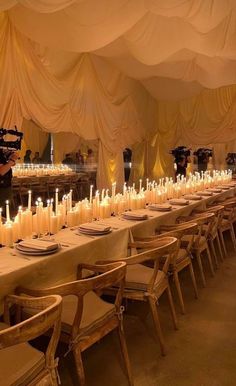 a long table with many lit candles on it in front of a camera set up for an event