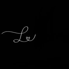 the word love is written in white ink on a black background with a small heart