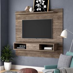 a living room with a couch, chair and television on the wall in front of it