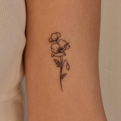 a small flower tattoo on the arm