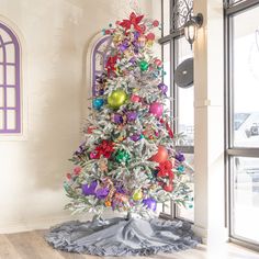 a decorated christmas tree sitting in front of a window