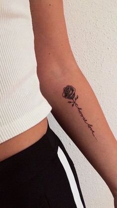 a woman's arm with a small rose tattoo on the left side of her arm