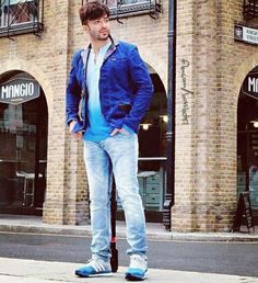 a man standing on top of a skateboard in front of a building