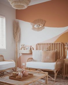 a living room filled with furniture next to a wall painted in orange and white colors