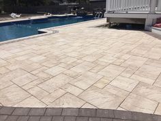 an empty swimming pool in the middle of a backyard with patio furniture and steps leading up to it