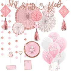 pink and white party decorations including balloons, tassels, paper fans and more