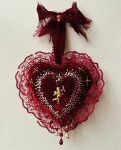 a red heart hanging on the wall with a small figure in it's center