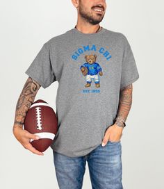 a man holding a football and wearing a t - shirt