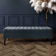 a bench with feathers on it in front of a blue wall and wood flooring